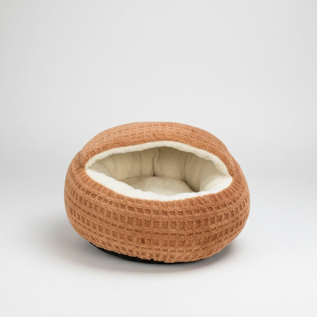 A round, waffle-textured pet bed in a warm tan-brown color with a soft cream-colored fleece lining, shown on a solid white background.