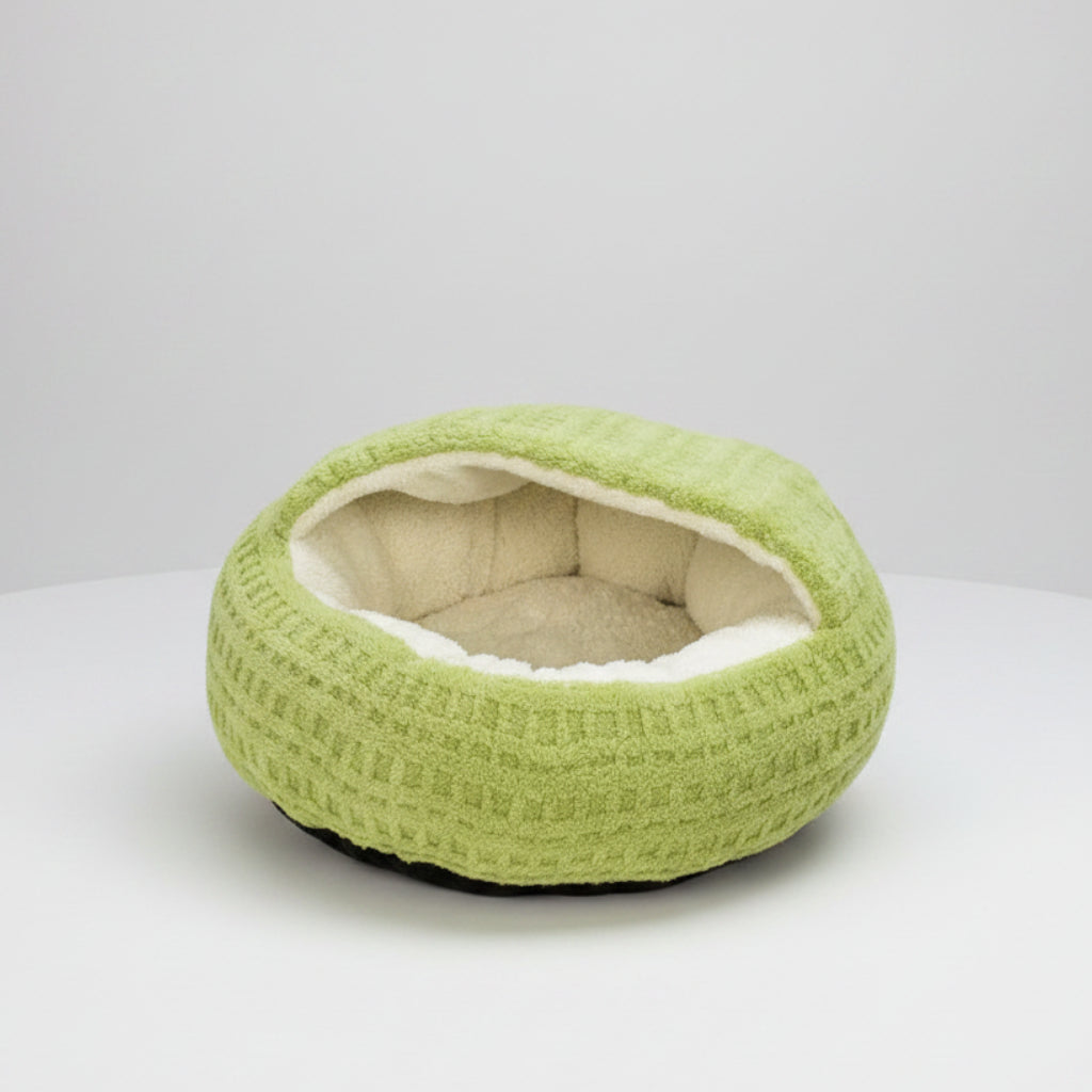 A round, waffle-textured pet bed in light green with a soft, cream-colored fleece lining, shown on a solid white background.