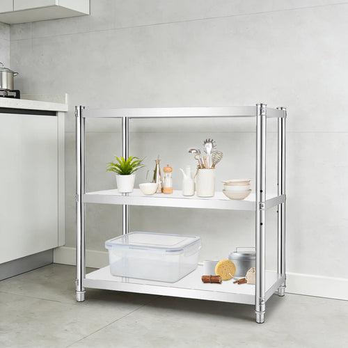 A three-tier kitchen organizer shelf with a chrome silver metal frame and white shelves, styled with kitchenware and food items in a modern kitchen setting.