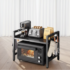 Black kitchen island with oven, toaster, coffee maker, and utensils on a white background