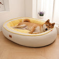 Dog lying on a round, cushioned pet bed with yellow interior in a room with light wood flooring and a window.