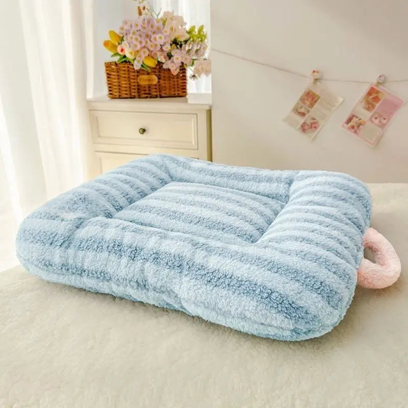 Fluffy blue pet bed on a light-colored couch with a decorative background