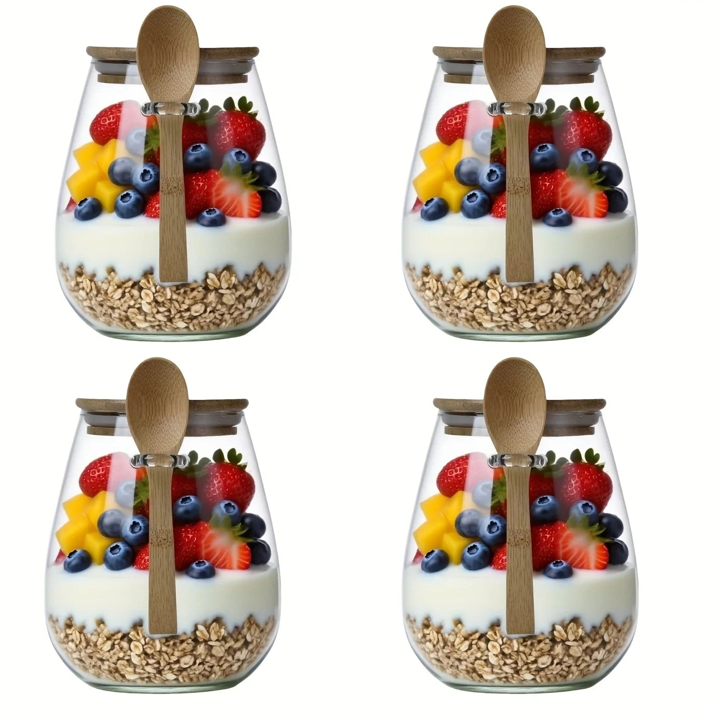 Four glass jars with fruit and granola mixtures, each containing a wooden spoon, on a white background.