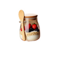 Glass jar with wooden spoon and berries on a white background