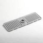 Gray rubber mat with drainage holes on a white background