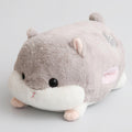 Plush toy hamster on a brown surface with a blurred background