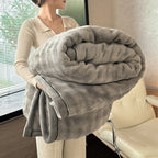 Person holding a large gray blanket indoors