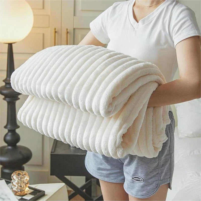 Person holding a large white blanket in a bedroom setting