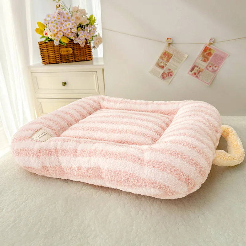 Pink pet bed on a light-colored surface with a decorative background