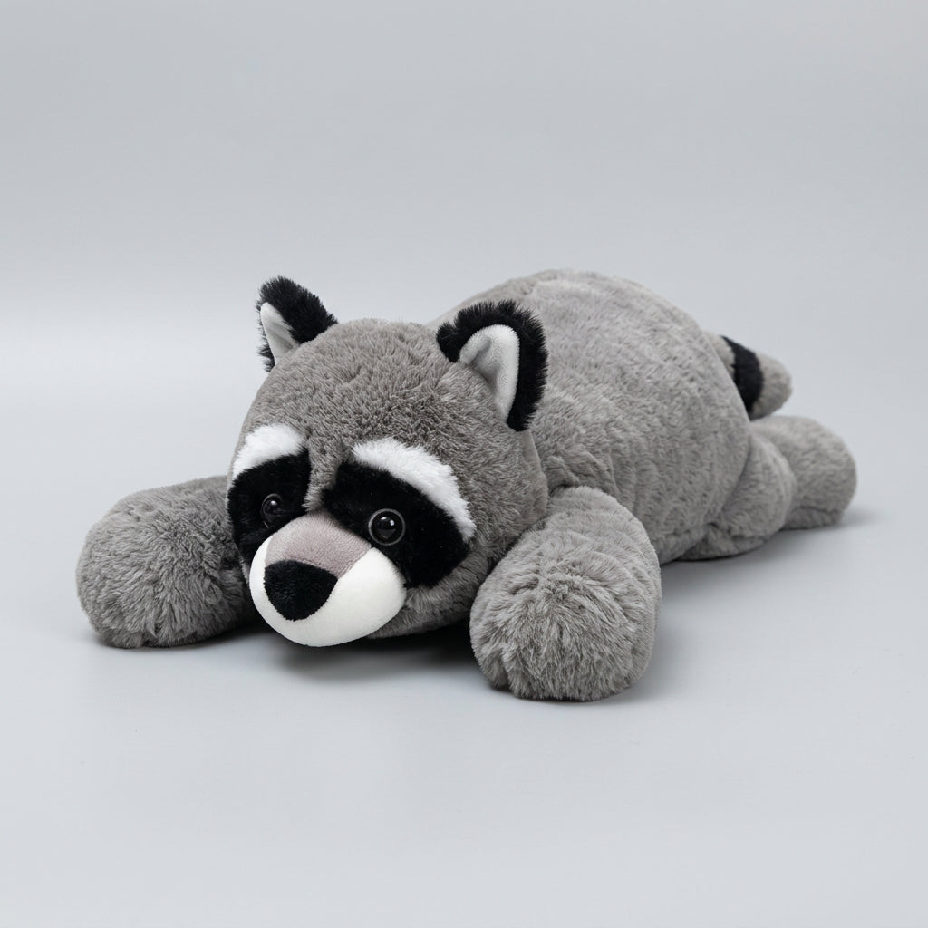 Plush raccoon toy lying on a woven mat with a blurred background
