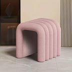 Row of pink stools against a neutral wall.