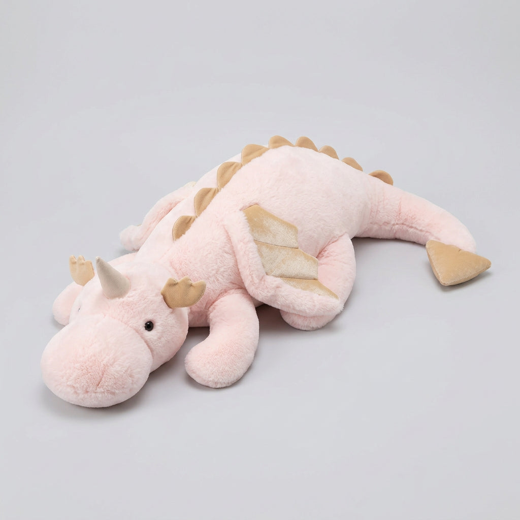 Plush dragon toy on a bed with a newspaper underneath