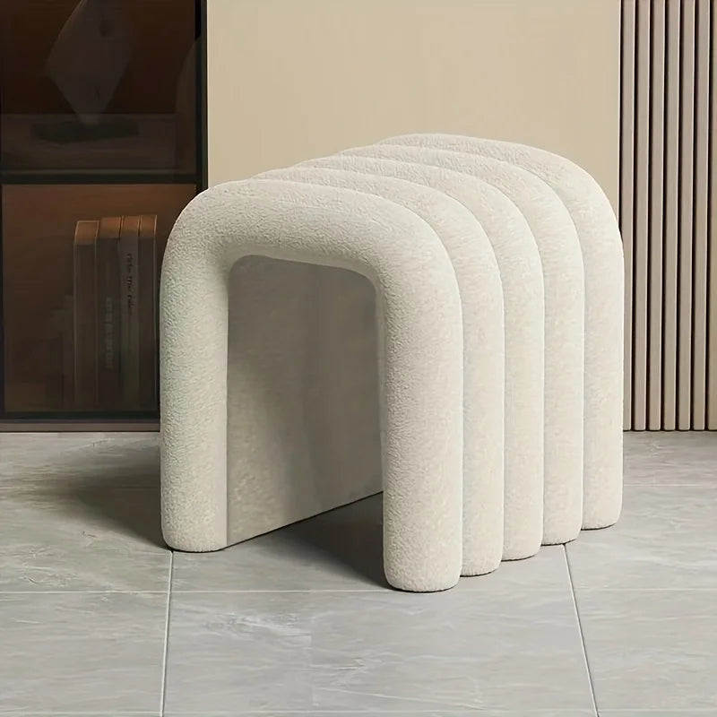 Set of four textured stools in a row on a tiled floor.