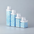 Set of glass canisters with blue and white contents on a white surface