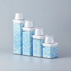 Set of glass canisters with blue and white contents on a white surface