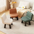 Three small upholstered child chairs in off-white, tan, and sage green are arranged on a light rug in a styled room with a sofa, curtains, and a decorative rabbit figurine.