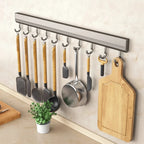 Wall-mounted kitchen hook rack with measuring dimensions on a light-colored wall.