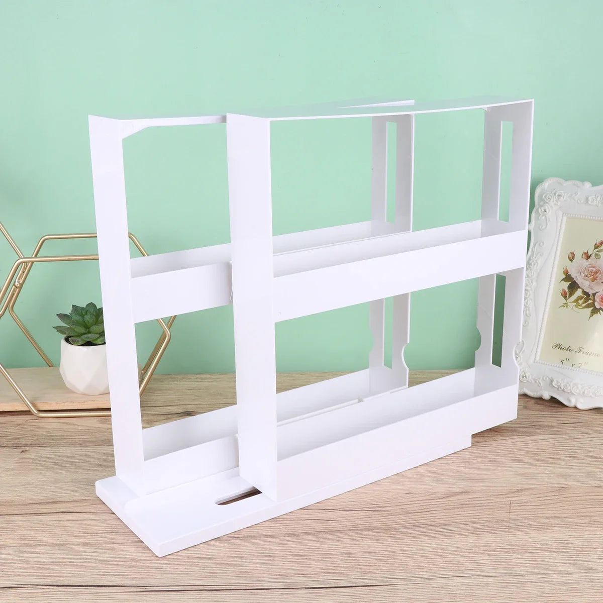 White magazine rack on a wooden surface with a light green wall in the background