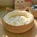 Woven pet bed with a soft cream cushion inside, placed on a textured surface.